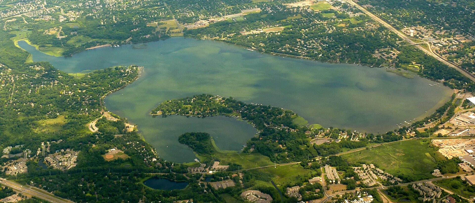 Aerial view of the Medicine Lake area, with a wooded peninsula and surrounding residential neighborhoods, photographed in July 2009