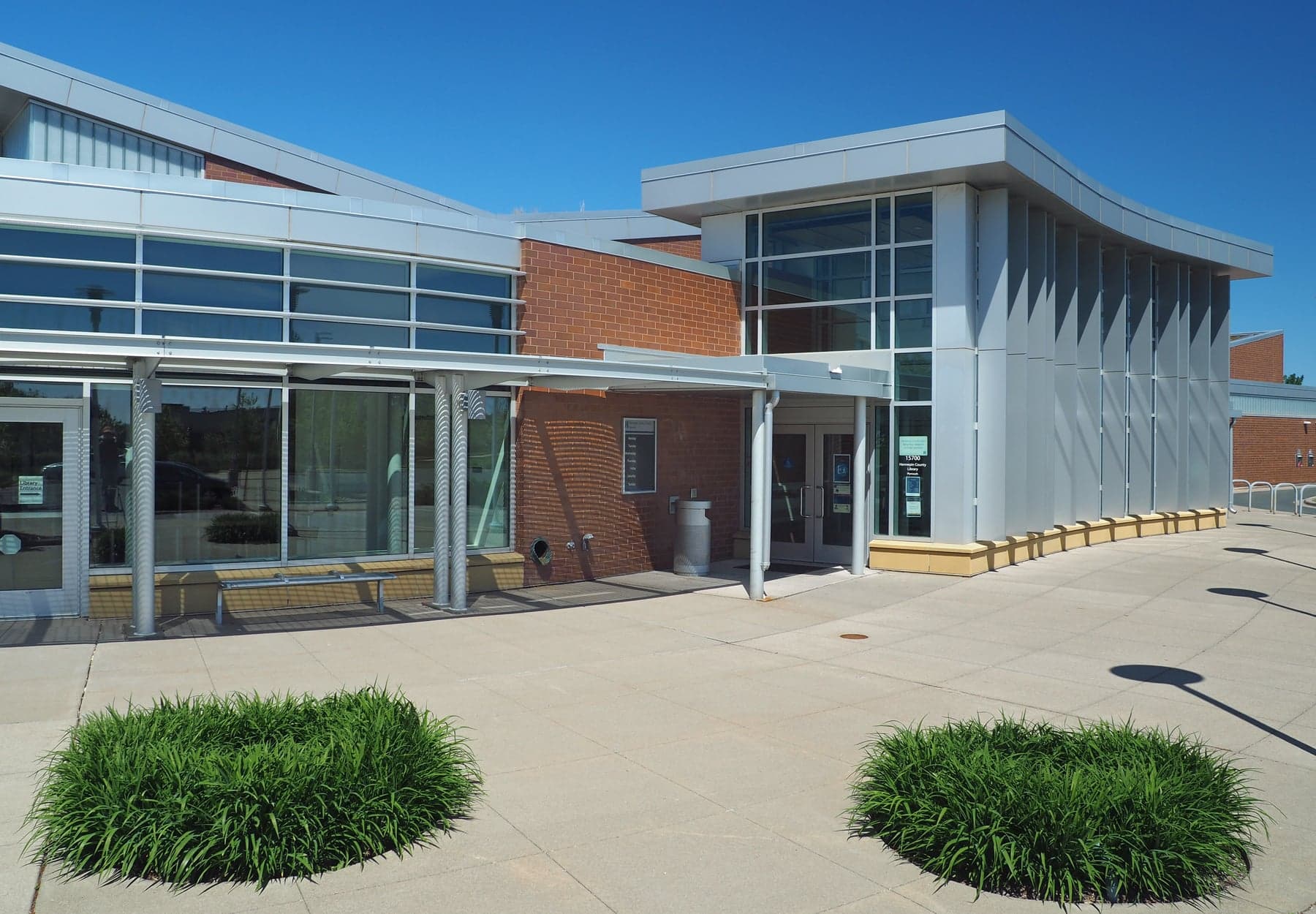Glass and brick entrance of Plymouth Library at 15700 36th Avenue North, photographed in May 2021