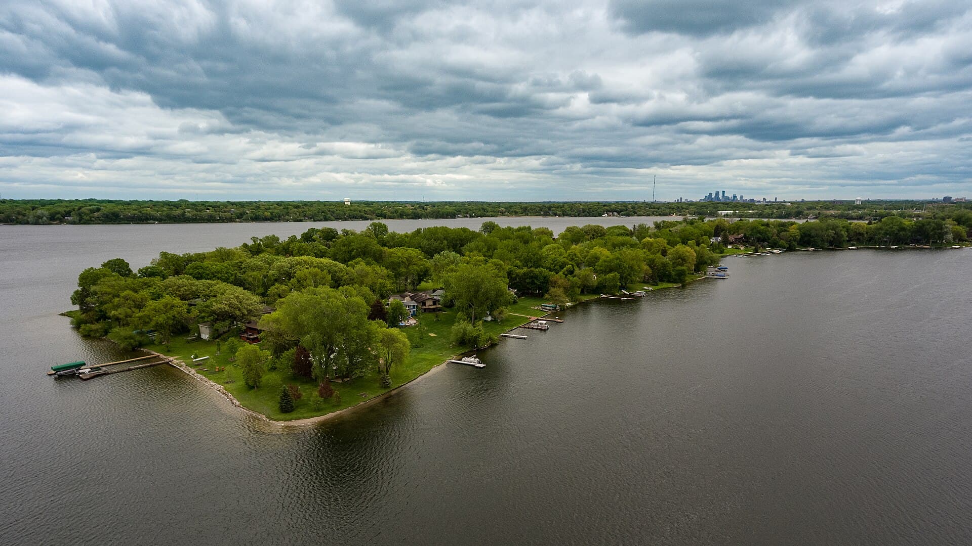 Medicine Lake in Plymouth, with wooded shoreline and the Minneapolis skyline in the distance